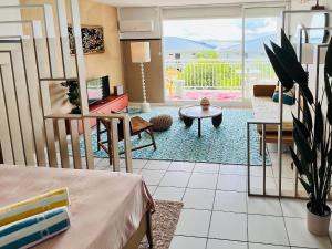 a living room with a couch and a table at Mont Vernon Top Secret Studio chic, plage et piscine Orient Bay in Cul de Sac