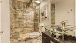 a bathroom with a sink and a toilet and a shower at Dolphin Point 402B - 2BR on Holiday Isle in Destin +13 photos