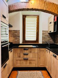 una cocina con armarios de madera y una ventana en Casa Maria, en Galluzzo