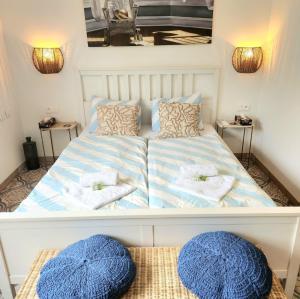 a bed with two blue and white pillows on it at Ron De Mar #2 modern room in Pezinok