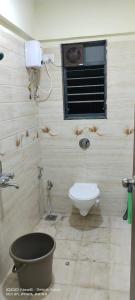 a bathroom with a toilet and a window at GharApna Hostel in Mumbai