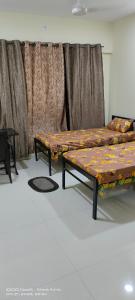 two beds sitting in a room with curtains at GharApna Hostel in Mumbai