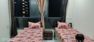 two beds in a room with pink comforter at GharApna Hostel in Mumbai