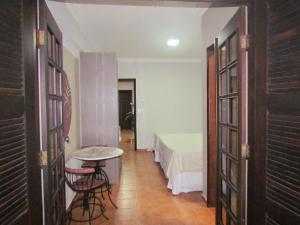 Pousada Villa Guimaraes في شابادا دوس غيماريش: ممر فيه سرير وطاولة في الغرفة