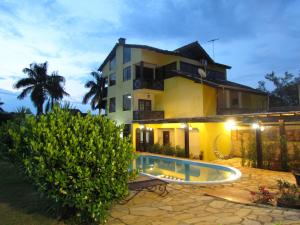 a house with a swimming pool in front of it at Pousada Villa Guimaraes in Chapada dos Guimarães