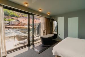 a bedroom with a bed and a balcony with an umbrella at STROFI Boutique Hotel in Tbilisi City