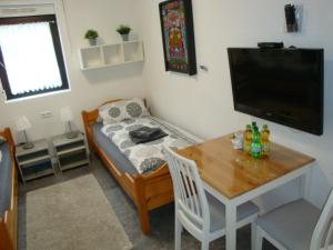 a small living room with a table and a television at Cenet 1 Zimmer Apartment in Sindelfingen