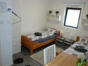 a small room with two beds and a table at Cenet 1 Zimmer Apartment in Sindelfingen