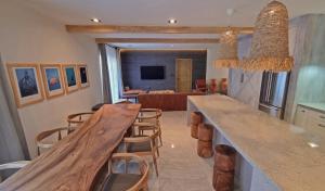 a kitchen with a long counter with chairs and a living room at Palacio Huatulco - 5F in Santa Maria Huatulco