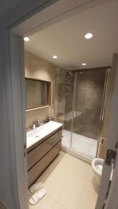 y baño con ducha, lavabo y aseo. en First Avenue AVM Residences, en Büyükçekmece