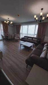 sala de estar con sofá, mesa y sillas en First Avenue AVM Residences, en Büyükçekmece