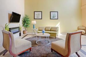 a living room with a couch and chairs and a tv at Best Western Plus Lonoke Hotel in Lonoke
