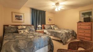 a bedroom with two beds and a dresser at Dolphin Point 404B - 2BR on Holiday with Views of Harbor in Destin +8 photos