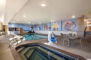 - une piscine avec une table et des chaises dans un bâtiment dans l'établissement Best Western Holiday Hotel, à Coos Bay