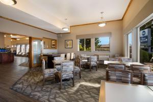Best Western Holiday Hotel في كوس بي: مطعم بطاولات وكراسي ونوافذ