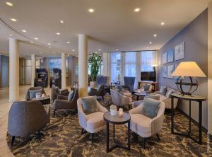 a lobby with chairs and tables and a waiting room at Dorint Strandhotel Binz/Rügen in Binz