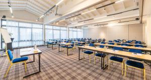 a room with tables and chairs in a classroom at Best Western Porte du Forez in Andrézieux-Bouthéon +70 photos