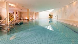 einen Pool in einem Hotel mit grünen Fliesen in der Unterkunft Dorint Strandhotel Binz/Rügen in Binz
