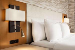 a bedroom with a bed with white pillows and a lamp at Radisson Blu Hotel Ahmedabad in Ahmedabad