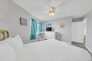 a bedroom with a white bed and a ceiling fan at Crystal Village II 18A - 2Bedroom 2BA Condo near the Beach Sleeps 6! in Destin