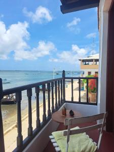 balcón con mesa y vistas a la playa en Pwani House - Lamu Seafront en Lamu