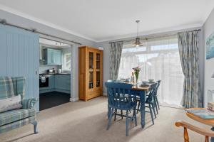 Una cocina y un comedor con mesa y sillas. en Brynawelon - Wonderful Sea and Harbour Views, en Saundersfoot 17 fotos más