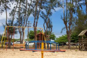 un parque infantil en la arena con árboles en el fondo en Ilha1 - Condominio Marinas Do Canal en Cabo Frío
