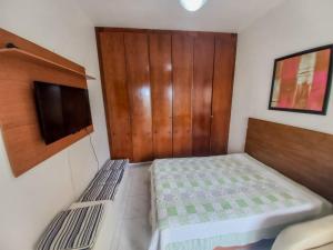 1 dormitorio pequeño con 1 cama y TV en Ilha1 - Condominio Marinas Do Canal, en Cabo Frío