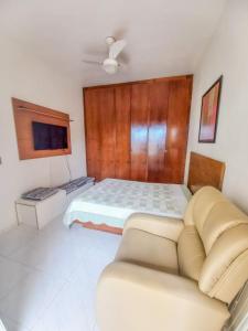 1 dormitorio con 1 cama y 1 sofá en Ilha1 - Condominio Marinas Do Canal en Cabo Frío