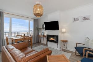 Una sala de estar con un sofá y una chimenea. en Sea Urchins - Sea Front Apartment with Views, en Saundersfoot