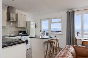 eine Küche und ein Wohnzimmer mit Meerblick in der Unterkunft Sea Urchins - Sea Front Apartment with Views in Saundersfoot