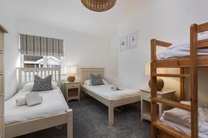 Un dormitorio con dos literas y una escalera. en Sea Urchins - Sea Front Apartment with Views, en Saundersfoot