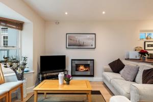 a living room with a couch and a fireplace at Park Place Court - Close to Beach with Parking in Tenby