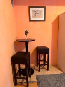 une petite table et deux tabourets dans une pièce dans l'établissement Bonita Habitación en chalet, à Barcelone