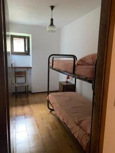 バゴリーノにあるAppartamento a Bagolino (BS)の二段ベッド2台と椅子が備わる客室です。