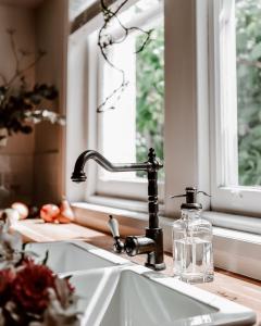 a kitchen sink with a window and a soap bottle at Gatekeepers Lodge - A Historic Hobart Experience in Hobart