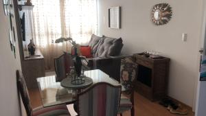 a living room with a table and a couch at Apartamento encantandor-perto centro e shopping in Poços de Caldas