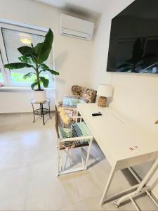 a living room with a white desk and a plant at Ron De Mar #1 modern room in Pezinok