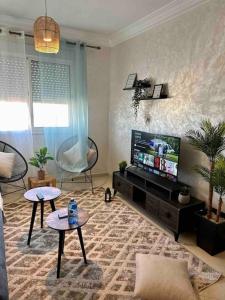 un soggiorno con TV a schermo piatto e divano di Beautiful apartment-High speed WIFI-iPTV-Netflix a El Jadida