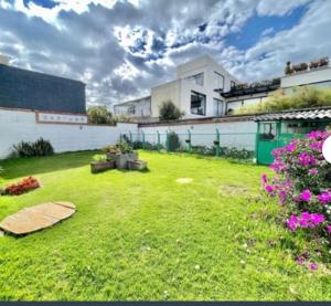 a backyard with a lawn with purple flowers at Casa Tipo Chalet especial Grupos grandes in Bogotá