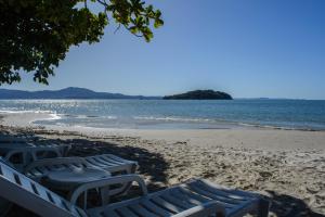 a group of chairs on a beach with the ocean at Mighil Hotel & Eventos in Florianópolis