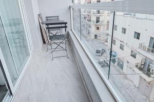 a balcony with a table and a view of a city at Brand new apartment close to Valletta in Tal-Pietà