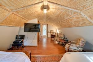 a room with a bed and a tv and a couch at Pet-Friendly Springville Cabin Near Kentucky Lake! in Durham Subdivision