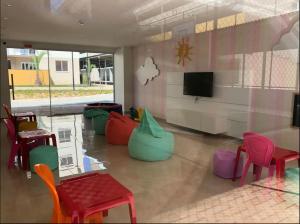 舊巴拉的住宿－Resort Apto Frente Mar，客房设有色彩缤纷的椅子和平面电视。