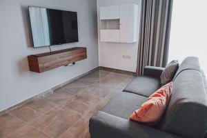 a living room with a couch and a flat screen tv at Brand new apartment close to Valletta in Tal-Pietà
