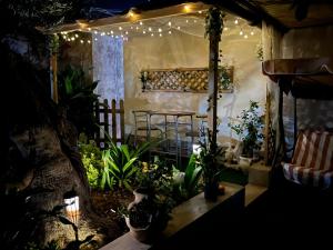 a patio with a table and lights and plants at Casa di Mirto in Chiaramonte Gulfi