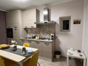 a kitchen with a table and a stove top oven at Casa di Mirto in Chiaramonte Gulfi