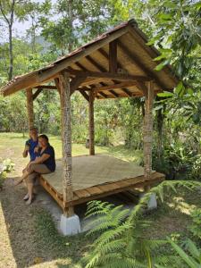 芒希的住宿－Rumah atlas，两人坐在木制凉亭里