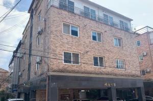 um edifício de tijolos com uma varanda em cima em Miranda House em Jeonju