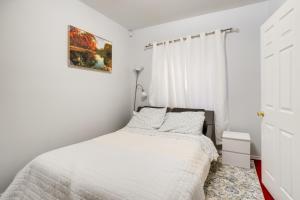 a white bedroom with a bed and a window at Convenient Denver Apartment about 10 Mi to Downtown! in Aurora